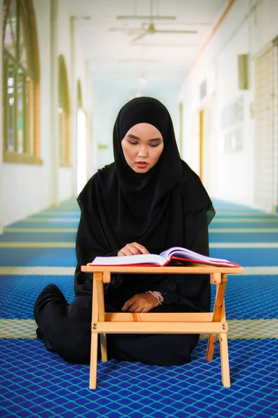A fiatal muszlim nő Al Koránt szavalt egy mecsetben. Az Al Korán egy iszlám szent könyv. — Stock Fotó