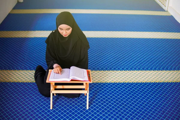 Jovem muçulmana recitando Al Quran dentro de uma mesquita. Al Quran é um Livro Sagrado Islâmico — Fotografia de Stock