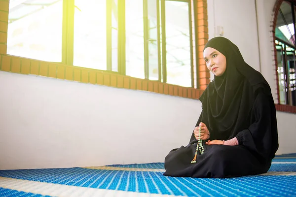 Молода муслімна жінка, яка молиться, dzikir до Аллаха під час молитви намистини в мечеті. — стокове фото