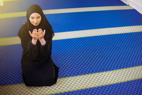 モスクの中で両手を上げてアッラーに祈る若いムスリム女性 — ストック写真