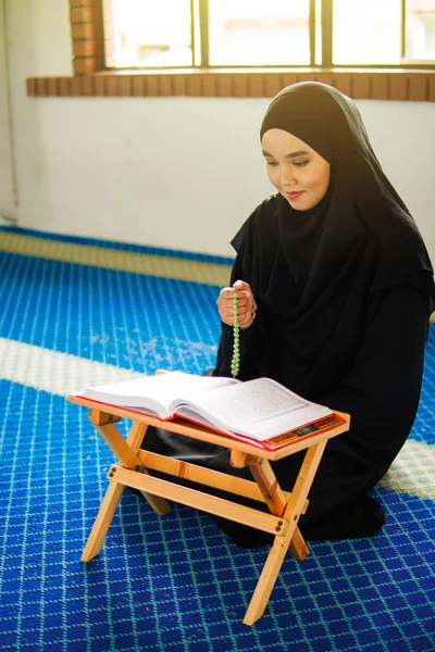 Jovem mulher muçulmana orando, dzikir a Deus, enquanto segurando uma pérolas de oração dentro de uma mesquita — Fotografia de Stock