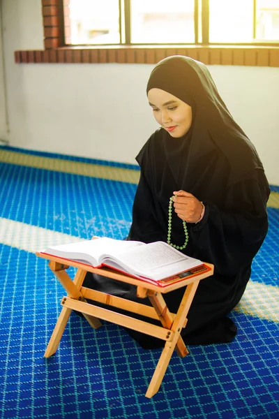 Jovem mulher muçulmana orando, dzikir a Deus, enquanto segurando uma pérolas de oração dentro de uma mesquita — Fotografia de Stock