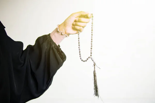 Mano de mujer musulmana rezando mientras sostiene cuentas de oración, tasbih sobre fondo blanco — Foto de Stock