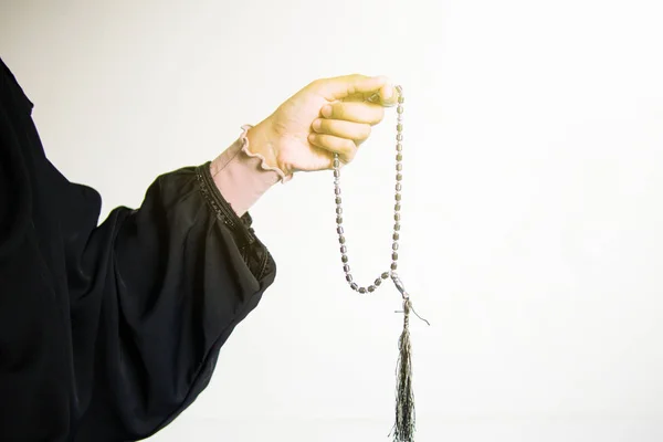 Mano de mujer musulmana rezando mientras sostiene cuentas de oración, tasbih sobre fondo blanco — Foto de Stock