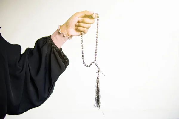 Mano di donna musulmana che prega mentre tiene perline di preghiera, tasbih su sfondo bianco — Foto Stock