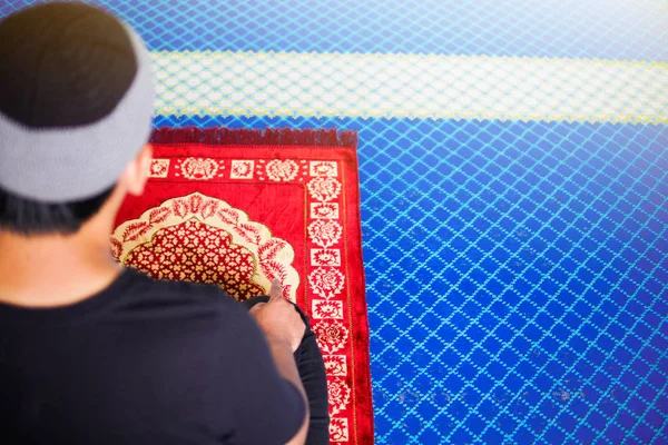 Muzulmán ember imádkozott, egy ujját fel az imádkozó szőnyeg belsejében egy mecset — Stock Fotó