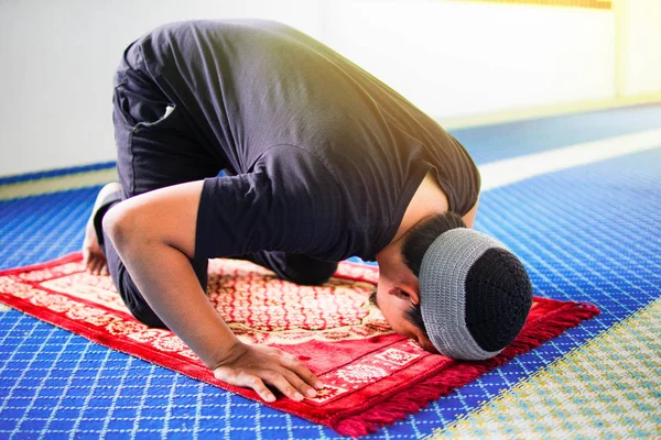 Religioso muçulmano homem rezando, prostrando-se em tapete de oração dentro da mesquita — Fotografia de Stock