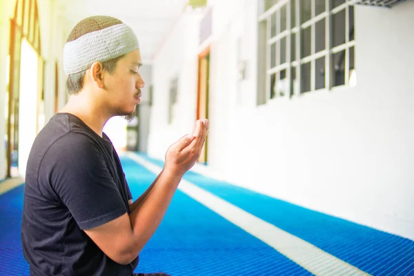 Vista superior del hombre musulmán haciendo du 'a rezando en alfombra de oración dentro de una mezquita —  Fotos de Stock