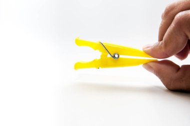 beyaz bir arka plan üzerinde izole bir clothespin tutan el