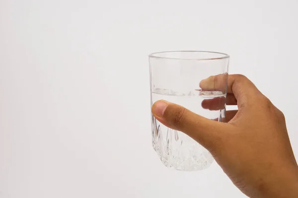 Ręka trzyma szklankę wody wyizolowaną na białym tle — Zdjęcie stockowe