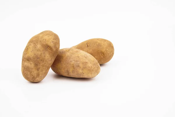 Três batatas cruas russet isoladas em fundo branco — Fotografia de Stock