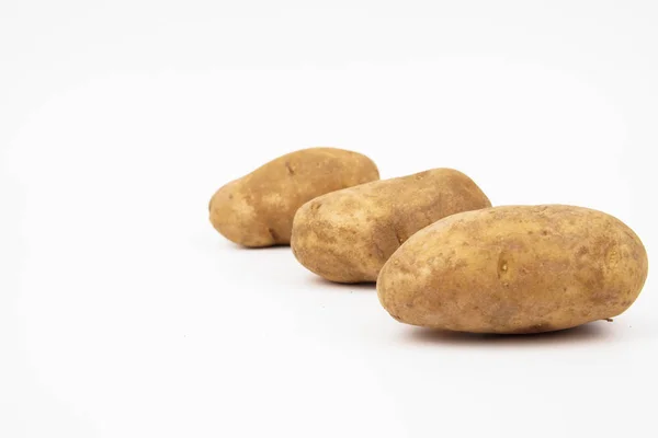 Beyaz arka planda izole edilmiş üç çiğ russet patates