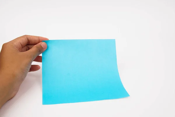 Une main tient du papier bleu vierge sur un fond blanc . — Photo