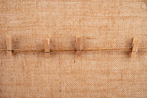 Kolekcja brązowych drewnianych szpilek na tkaninie workowej tekstury — Zdjęcie stockowe