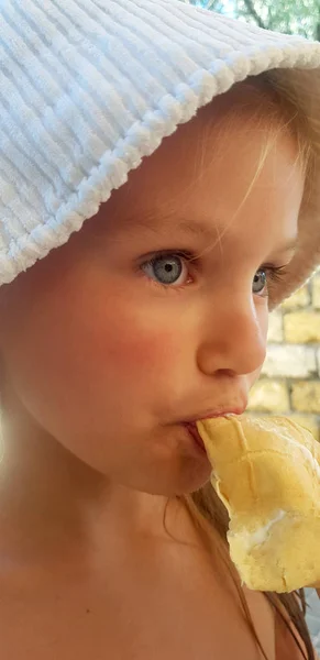 Fille dans un chapeau blanc mange crème glacée — Photo