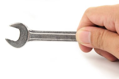 Beyaz arka plan üzerinde izole edilmiş küçük bir anahtarı veya anahtarı tutan yakın çekim el.