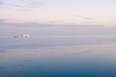 Günbatımı gökyüzü sonsuzluk havuzu suya yansıyan. Arka planda, turkuaz lagün Maldivler üzerinde bir tekne
