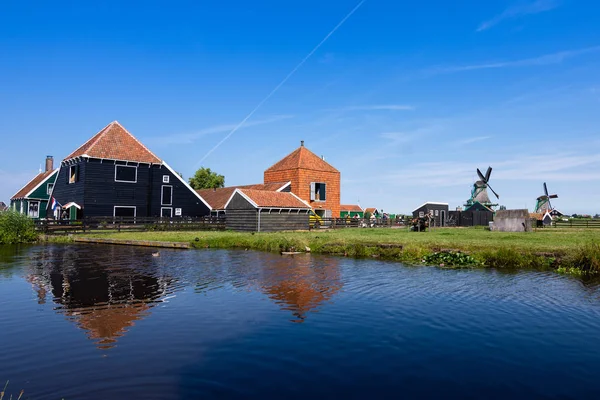 Reflections in the water of the farms and windmills on a lovely day, with a blue sky. Zaanse Schans. Holland