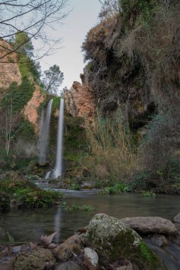 Şelale orman ve yosunlu kayalar ön planda peyzaj