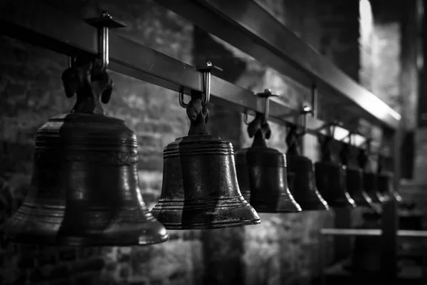 Many old bells seen in a row. Black and white image. The Belfry of Ghent, Belgium
