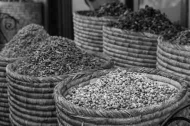 Kurutulmuş gül, lavanta, roselle çiçek dekorasyon karışımı için kullanın. Sepetleri renkli doğal organik bitkisel çay pazarında Marakeş, Fas. Siyah beyaz resim