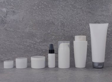 Kozmetik Ambalaj gri arka plan üzerinde ayarlayın. cilt bakım kremi serum petrol grubudur. yüz güzellik kozmetik spa ürün. Doğal kozmetik kavramı cilt tedavisi