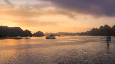 Vietnam, Güney Asya ve Turistik Junks gün doğumunda Halong bay. Panoramik manzara. Seyahat hedef ve doğal arka plan.