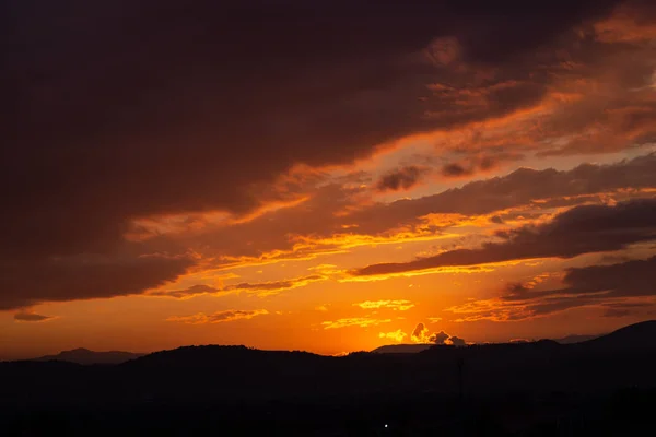 주황색 구름을 통해 빛나는 태양 빛과 풍경 — 스톡 사진