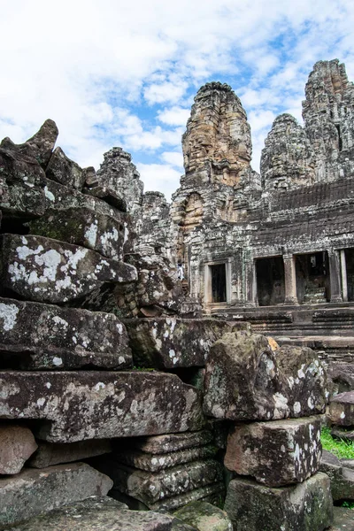 Many stones piled up in the ruins of Arkgon Thom with large statues in the background - World Heritage by UNESCO in 1992