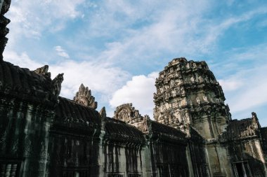 Kamboçya'da berrak mavi gökyüzü altında Ankgor Thom kentinde Bayon tapınağında rustik taşlardan yapılmış güzel heykel - Unesco tarafından 1992 yılında Dünya Mirası