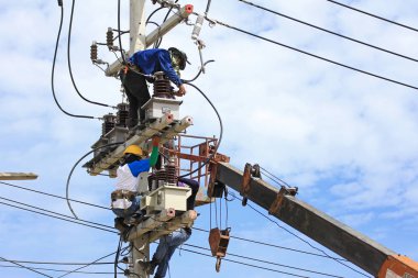 Yüksek gerilim elektrik direği üzerinde çalışan teknisyenler