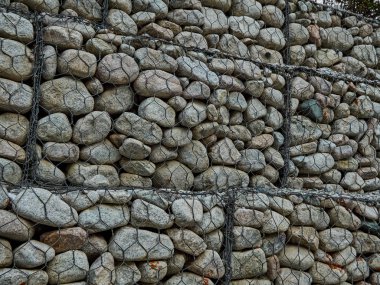 deniz kenarı suya karşı güçlendirmek için bir net bağlı taş dağ Nehri üzerinde bulanıklık