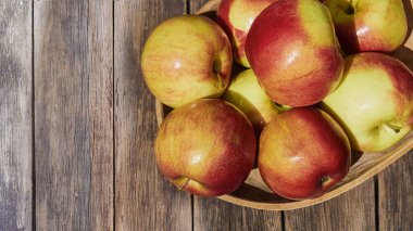 Ahşap eski bir masada yeşil yaprakları ile taze kırmızı elma. Ahşap bir arka plan üzerinde. Metin için boş alan. yukarıdan görünüm