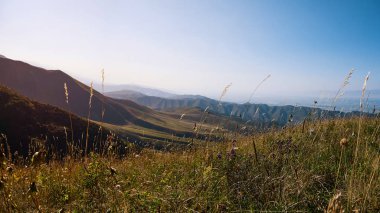 Yazın bir dağ vadisi manzarası, hava manzarası. Dağ tepelerinin üzerinde peri masalı günbatımı, inanılmaz doğa, dağlarda yaz. Seyahat, turizm. Doğanın güzel arkaplan resmi
