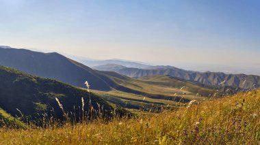 Yazın bir dağ vadisi manzarası, hava manzarası. Dağ tepelerinin üzerinde peri masalı günbatımı, inanılmaz doğa, dağlarda yaz. Seyahat, turizm. Doğanın güzel arkaplan resmi
