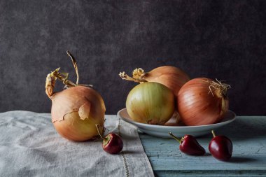 sebze natürmort, eski masada olgun soğan ve beyaz yemekler ile kompozisyon, gıda maddeleri, koyu tonalite, yakın çekim