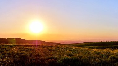 Yaz aylarında bir dağ vadisinin panoraması. Dağlarda muhteşem gün batımı, muhteşem doğa, dağlarda yaz. Seyahat ve kamp, turizm