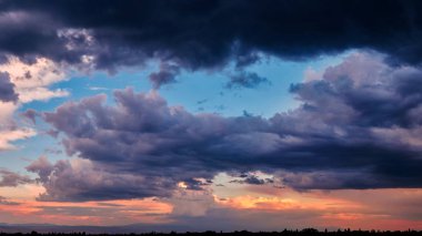 Gün batımında heyecan verici, parlak fırtınalı gökyüzünün arka planında bulutların arasından dramatik Bir ışık. panorama, doğal kompozisyon