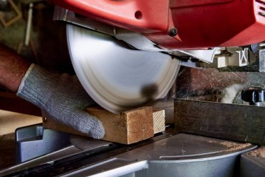 Marangoz marangoz atölyesinde ahşap işleme makineleri üzerinde çalışır. Bir adam ağaçla çalışır.