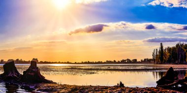 Gölün güzel panoramik manzarası, akşam güneşiyle aydınlanan renkli bulutlar, yaz maceraları, açık hava aktiviteleri, turizm lüksü.