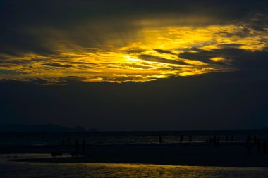 Harika dramatik akşam gökyüzü Twilight üzerinde okyanus, Seaside bankada kum üzerinde yürüyen siluet insanlar