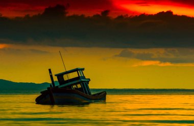 Su arka planda üzerinde dramatik akşam alacakaranlık gökyüzü bulut deniz kazasında tekne batıyor,