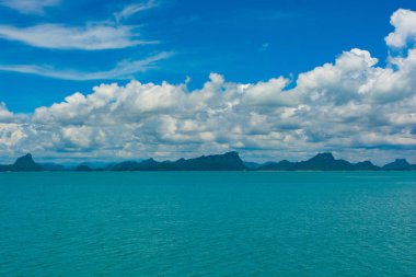Mavi gökyüzünde güneşli gün bitti Adası ve okyanus ötesinde harika beyaz bulut