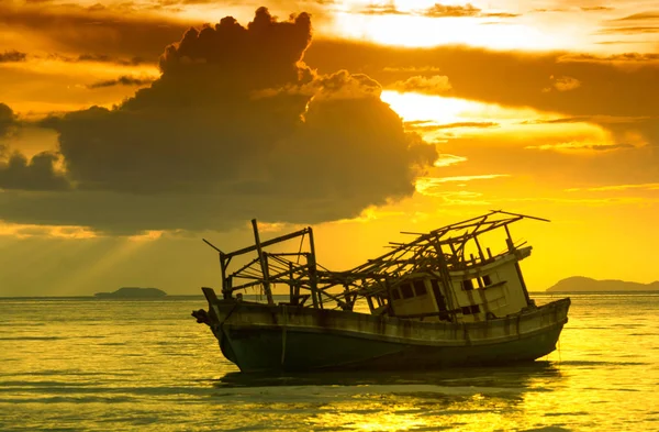 Balıkçı tekne karaya batık düşük gelgit Denizi, dramatik akşam alacakaranlık gökyüzü arka plan bulut
