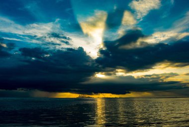 Arka plan bitti okyanusta yansıtan Sundown ışık ile dramatik gökyüzü kara bulut