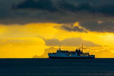 Feribot Tekne deniz yolculuğu, kara bulut gün batımından yukarıda arka planda altın çatı penceresi