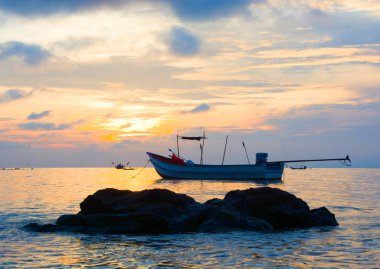 Günbatımı manzara akşam, balıkçı tekne demirlemiş kayanın arkasında, gün batımı Twilight bulut arka plan