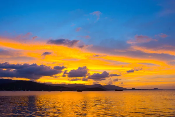 TWILIGHT GOLDEN BLUE SKY CLOUD ABOVE ISLAND AND THE SEA IN LATE EVENING TIME