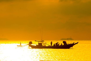 Siluet grup balıkçı teknelerinde geç batı deniz kenarında, harika karanlık altın ışıklık akşam dinlenme arka plan bulut