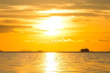 Uzun menzilli harika altın ışıklık bulut okyanus arka plan üzerinde gün batımına saat akşam deniz yolculuğu sırasında siluet Cruise gemisiyle